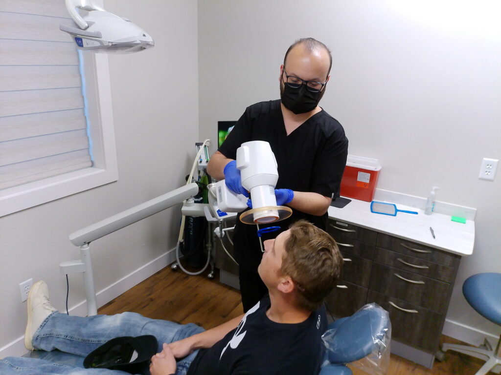Dentist treating patient with digital X-ray technology at Lamb Family Dental